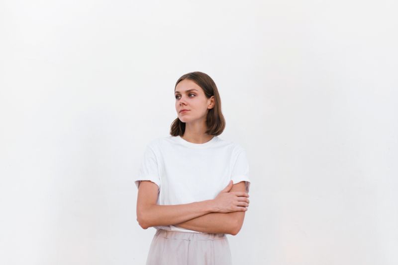 young woman looking off in the distance with arms crossed